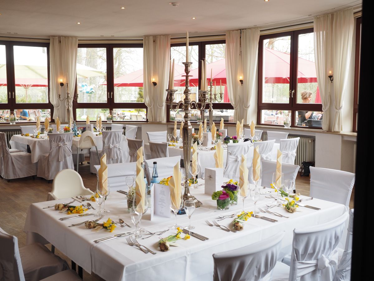 Ballroom set with round banquet tables under chandeliers