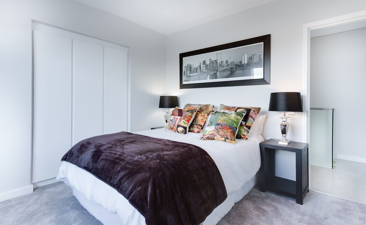 Made bed with layered linen and a upholstered headboard